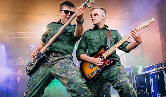 Två soldater spelar gitarr och bas på scenen