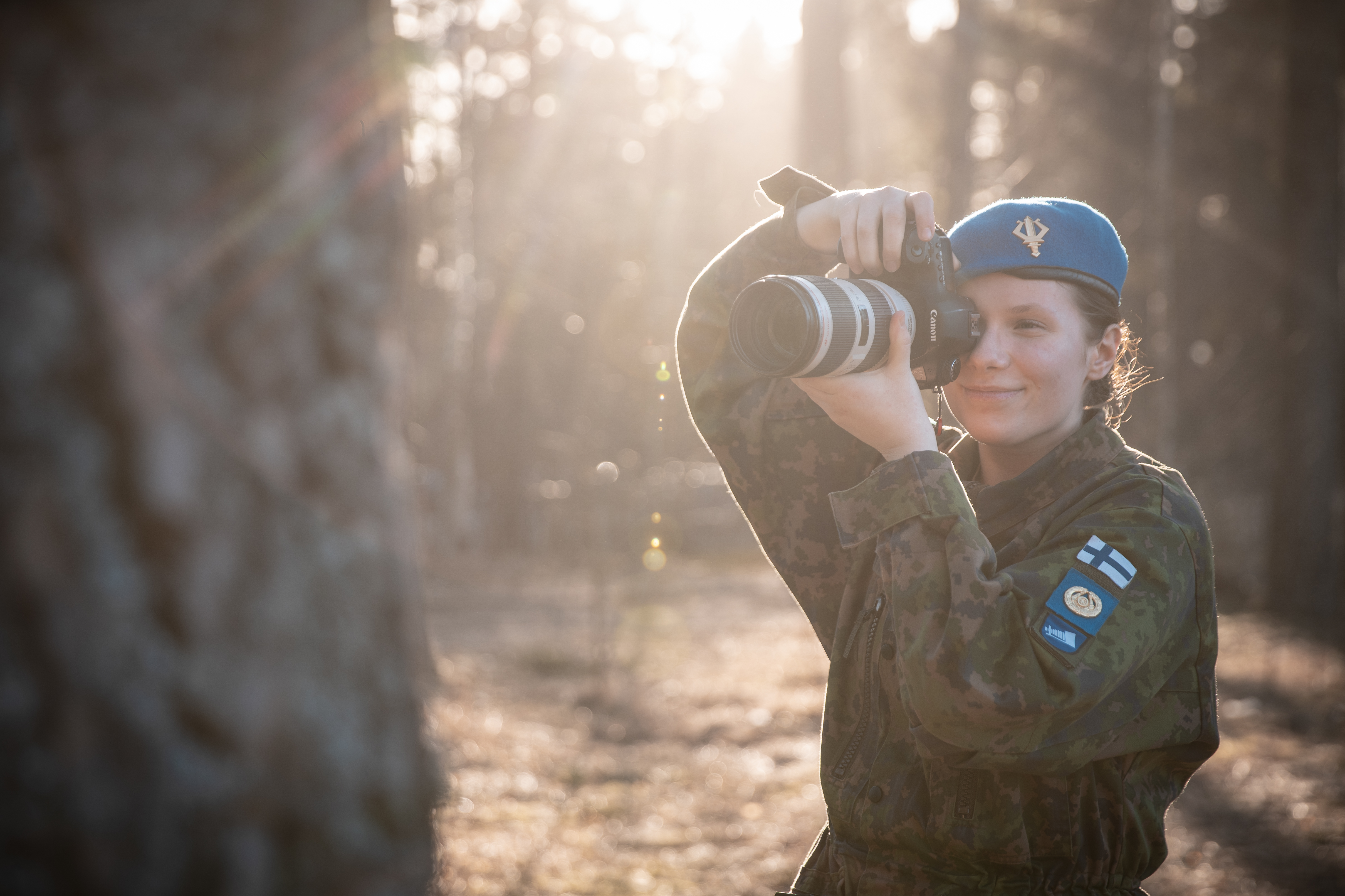 A conscript woman takes a picture with a SLR camera